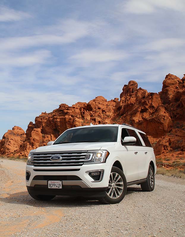 Ford SUV driving through rocky mountains.